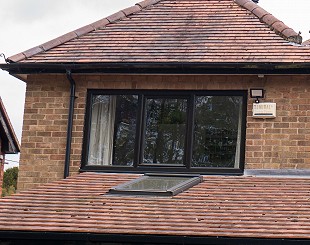 Grey UPVC tilt and turn window on a home